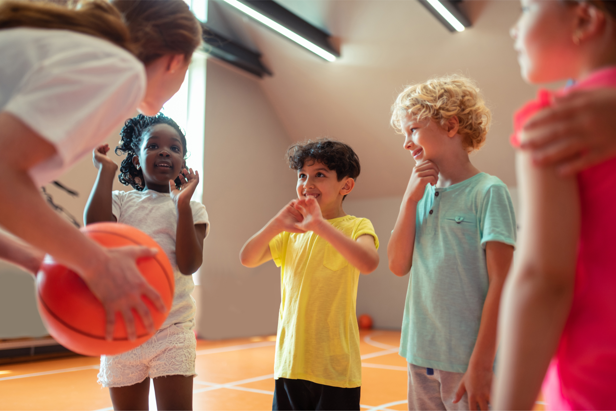 Children enjoying basketball together with a coach