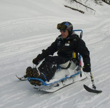 Dick Taylor demonstrates sit-skiing to his instructors at Sun Peaks