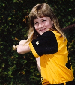 Darcy posing with a baseball bat for team photos in Grade 6. 