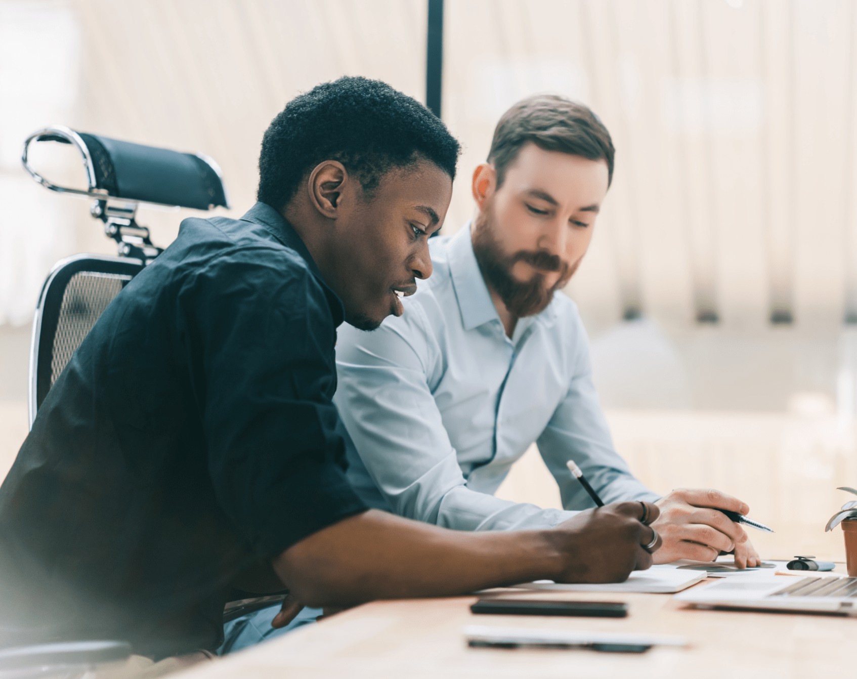 Two office workers discussing an item.