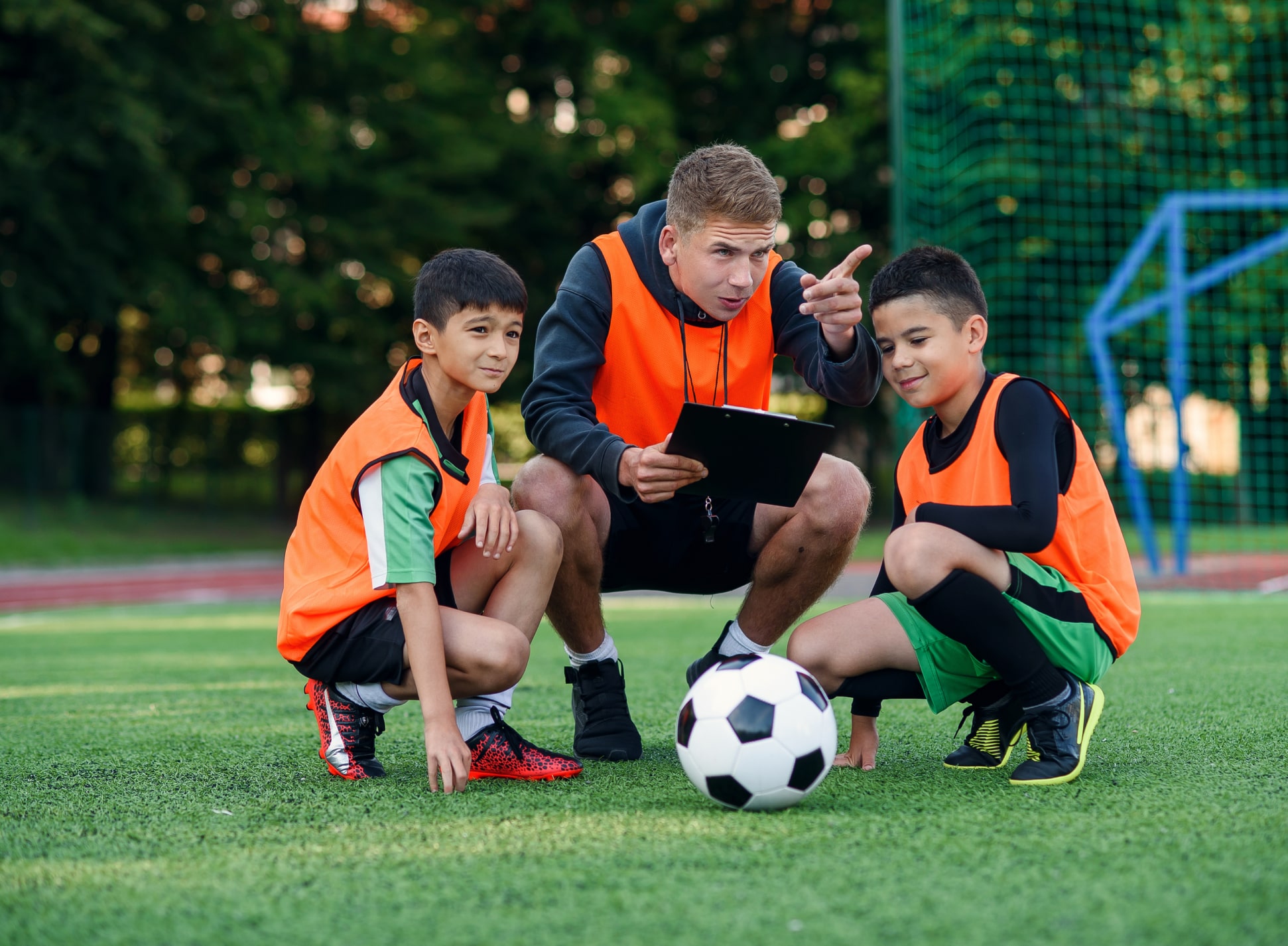 Soccer coach guiding youth soccer athletes