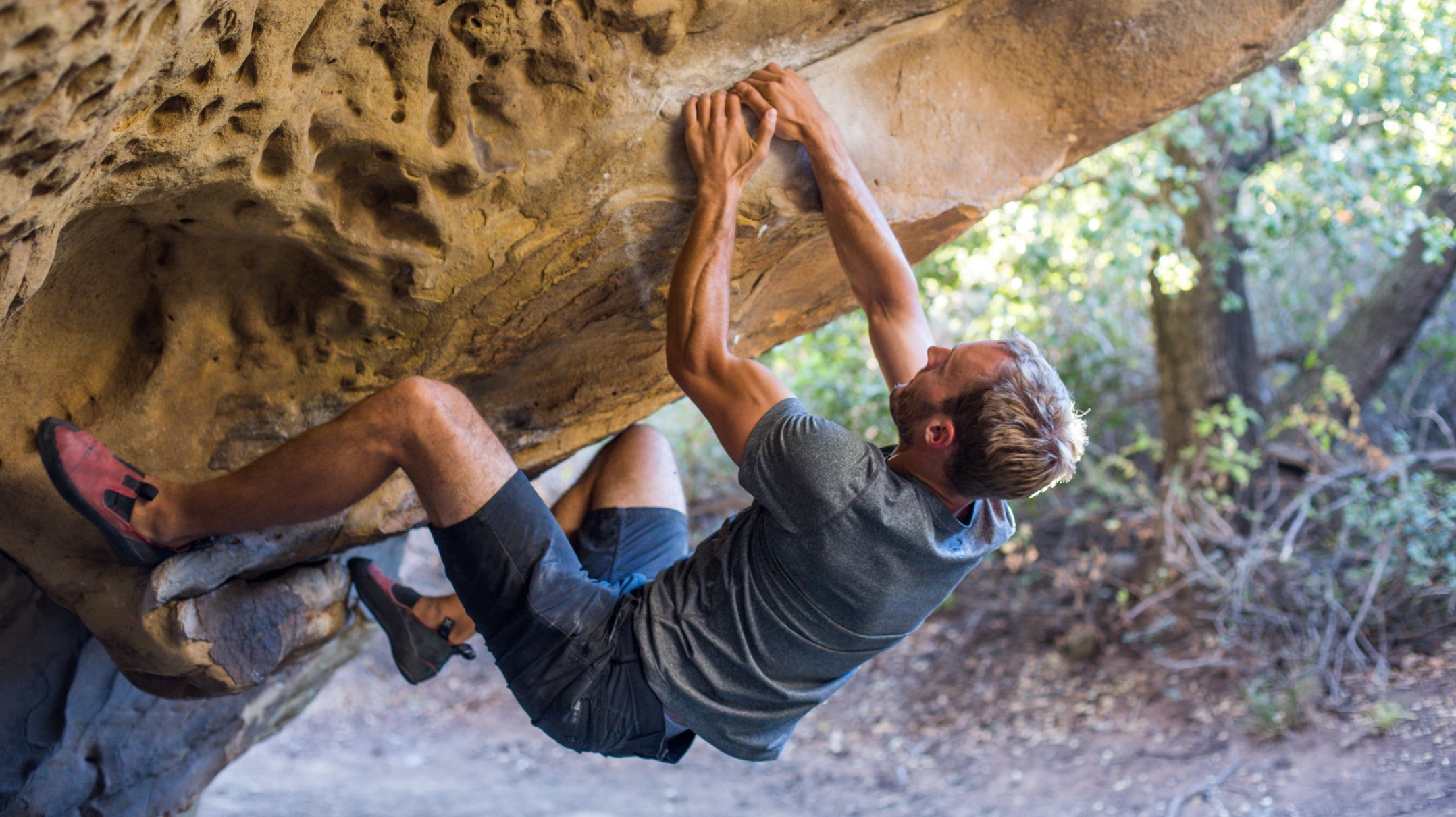 Rock climber taking tremendous effort for his next move