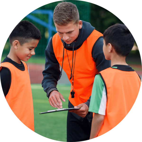 Young volunteer helping out children at a sport event